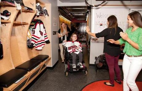 Hockey team members greet Marianne in the locker room.
